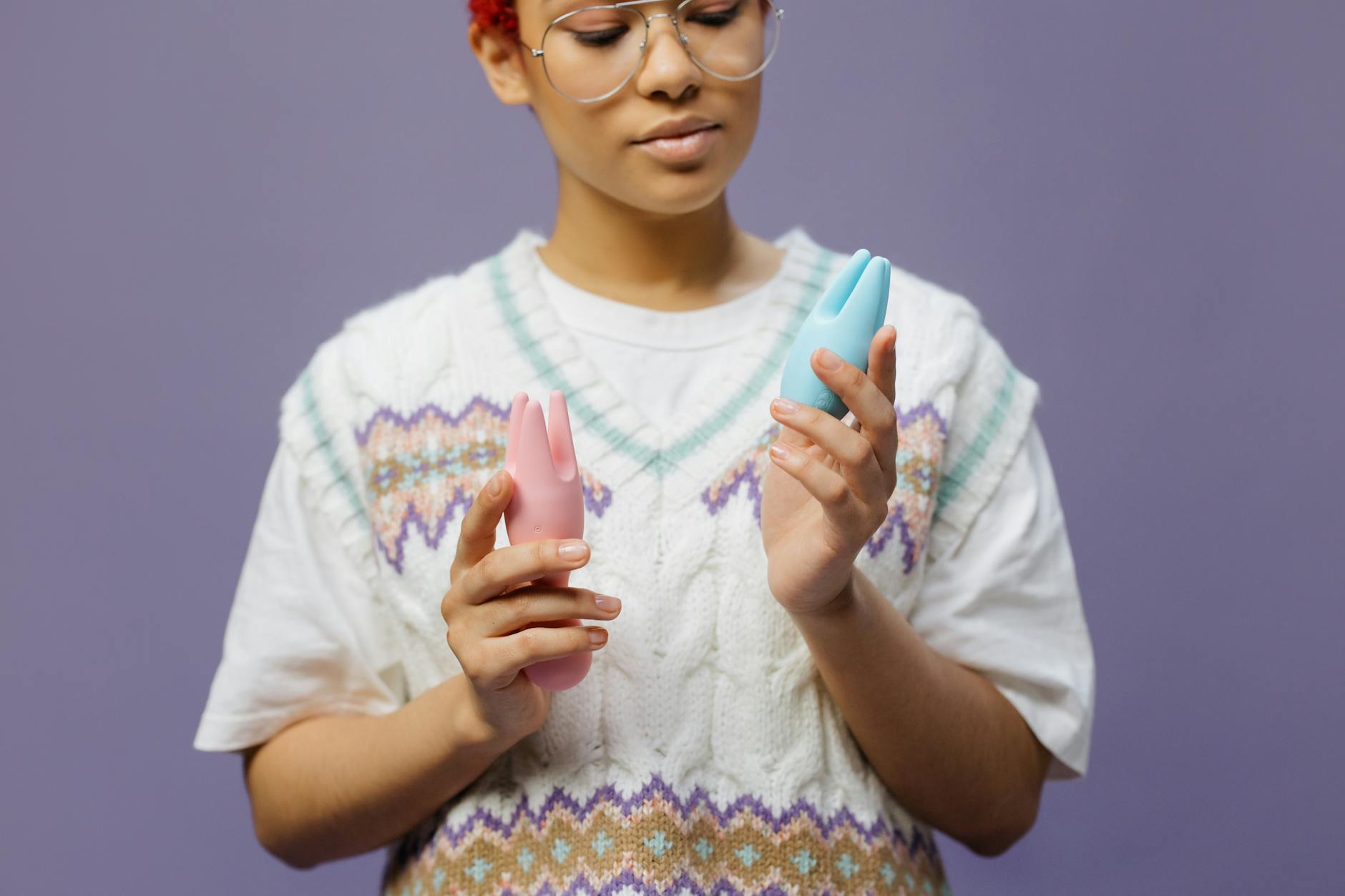Hand holding a blue silicone vibrator in contemplation