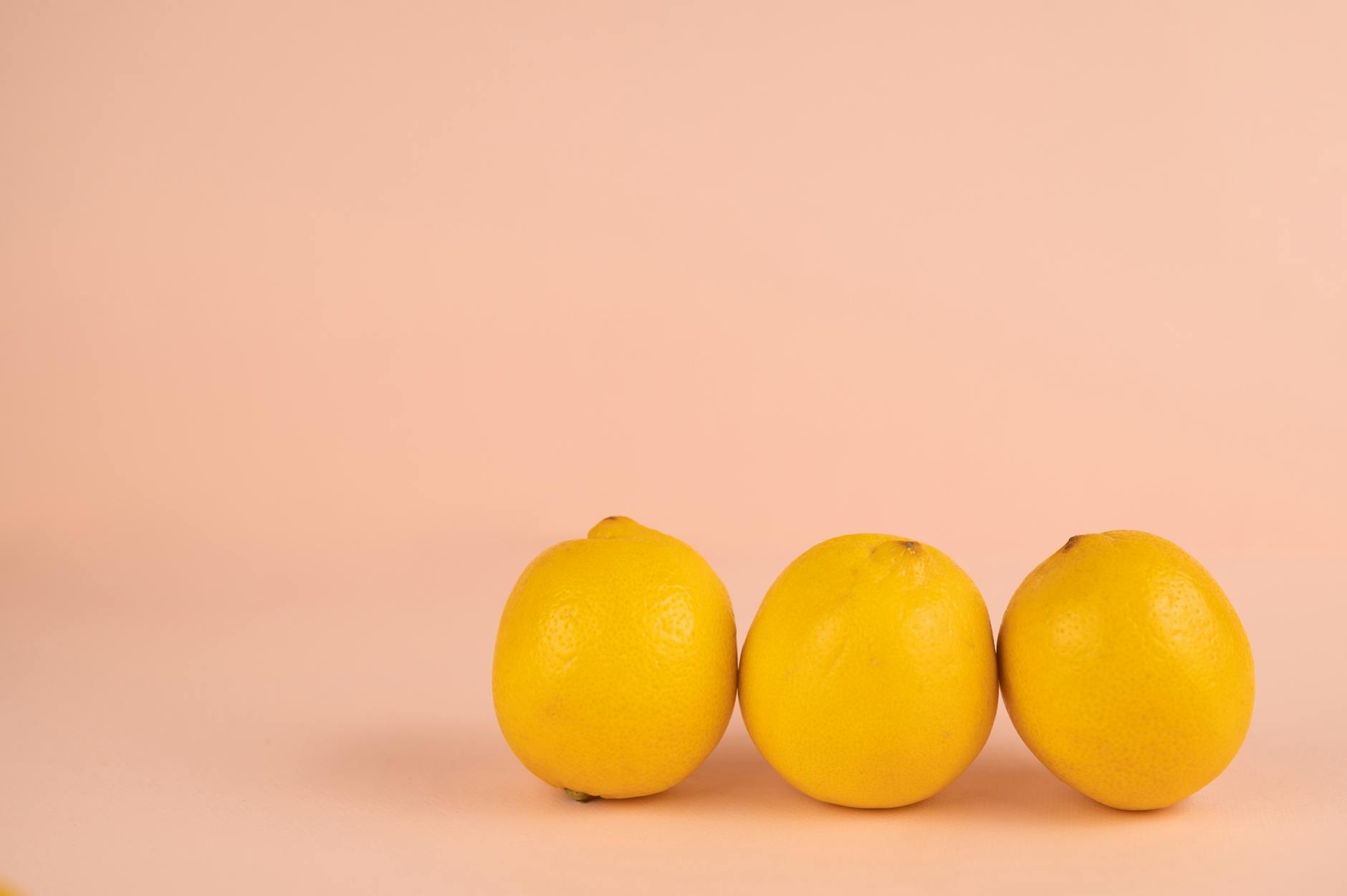 Bright yellow lemons arranged on a pastel background, symbolizing natural cycles and freshness